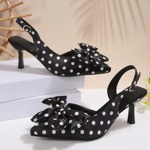 Gros plan sur les sandales en satin noir à pois blancs avec un nœud décoratif élégant