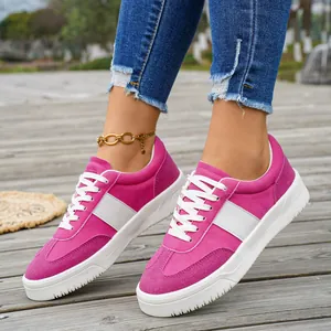 Vue détaillée de baskets basses roses en daim pour femmes sur un pont en bois