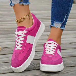 Détail de baskets basses pour femmes rose fuchsia sur un ponton en bois à l'extérieur