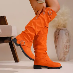 Stylish slouchy orange over-the-knee western boots with buckle details and flat heels