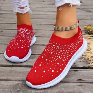 Vista dettagliata di scarpe da ginnastica rosse traspiranti con strass luminosi.