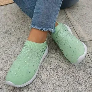 Dettaglio di sneaker in maglia verde menta traspirante con strass scintillanti.