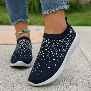 Primo piano di scarpe slip-on blu scuro in maglia traspirante con strass scintillanti