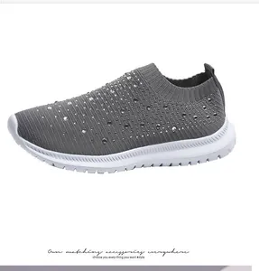 Dettaglio di sneaker in maglia grigia traspirante con strass scintillanti