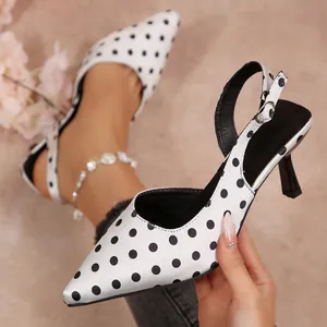 Vue détaillée des sandales à pois en satin blanc avec un talon haut et fin.