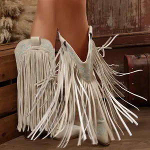 Close-up of beige Western cowboy boots with long tassels and blue embroidery detailing.
