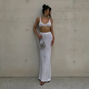 Close-up of white knit two-piece set with crop top and high-waisted maxi skirt