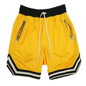 Vista dettagliata dei pantaloncini da basket in mesh giallo traspirante con tasche a zip funzionali