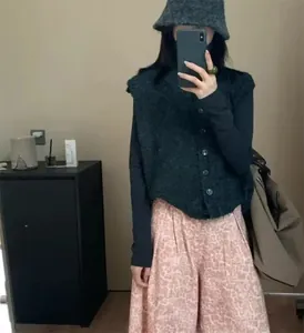 Selfie miroir d'une femme portant un gilet en laine bouclée grise et un pantalon rose