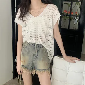 Top de punto calado blanco con cuello en V combinado con shorts vaqueros