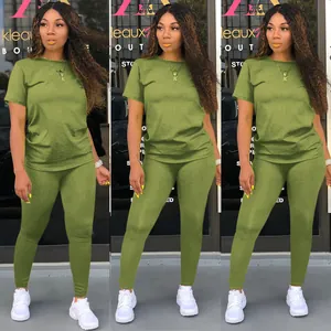Full view of olive green solid color two-piece crew neck t-shirt and leggings outfit set