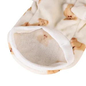 Detailed close-up of thick white flannel pet shirt with cute brown bear patterns