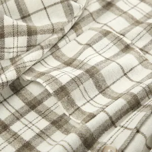 Macro detail showing soft vintage plaid fabric texture and pocket of a casual shirt