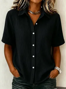 Close-up of a stylish black cotton button-down shirt with a crinkled fabric texture.