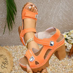 Detailed side view of orange platform sandals with chunky heels and silver buckle accents.