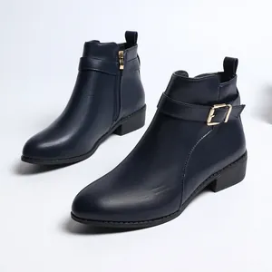 Vista lateral de botines de cuero azul oscuro con elegante hebilla dorada y cremallera