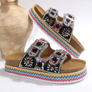 Detailopname van etnische platformsandalen met gekleurde kralen en dubbele gespen
