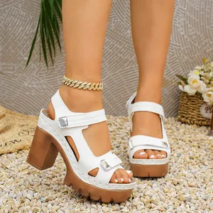 Close-up of stylish white platform sandals featuring velcro straps and brown block heels