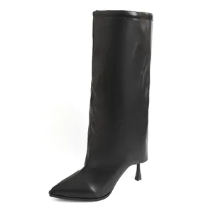 Détail de bottes noires à bout pointu avec talons aiguilles et design de jambe de pantalon.