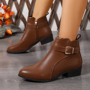 Vista detallada de botines de cuero marrón de estilo británico con hebilla y cremallera lateral