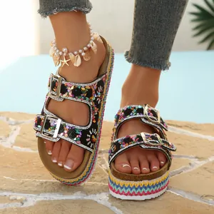 Detailopname van bohemian plateau slippers met kleurrijke kralen en dubbele gesp.