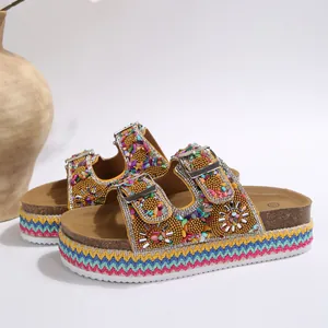 Detailweergave van etnische platform sandalen met strass gespen en kleurrijke geweven zool.