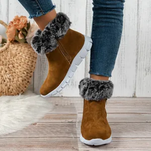 Close-up of warm brown suede snow boots with soft gray faux fur trim and white soles