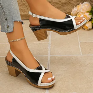 Detail view of black and white color-block mid-heel sandals with elegant Roman style straps.