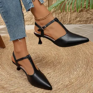 Elegantes sandalias negras de punta con tacón de aguja y diseño de tira en T en modelo.