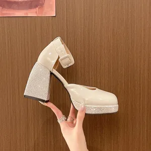 Gros plan détaillé de chaussures Mary Jane en cuir verni beige avec talon en strass