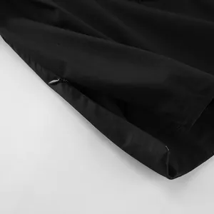 Close-up detail of the invisible side zipper on a black high-waisted asymmetric skirt