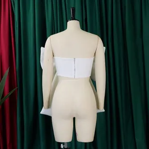 Vista posteriore di elegante top a fascia bianco con fiocco oversize.