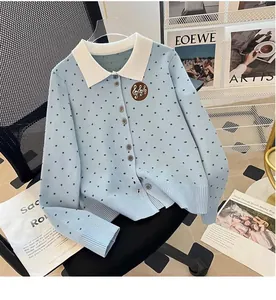 Detailed view of grey polka dot knit cardigan featuring white collar and badge