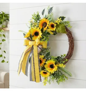 Artificial sunflower wreath featuring yellow ribbon and green leaves on vine base