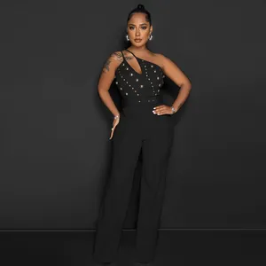 Detail view of a black one-shoulder jumpsuit with gold studs and flared wide-leg trousers