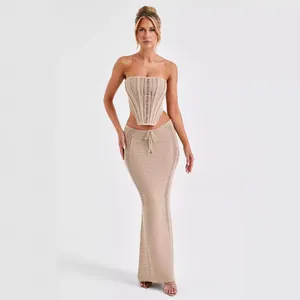 Detalle de un conjunto de punto de dos piezas beige con top palabra de honor y falda