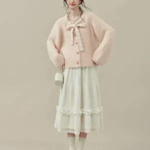 Cardigan rosa in maglia con fiocco e gonna bianca a balze in stile dolce e romantico