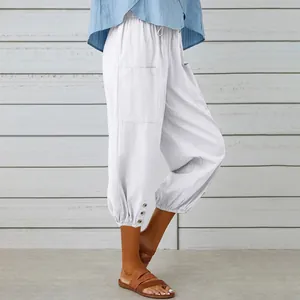 Close-up of white cotton linen cropped pants with drawstring waist and buttoned cuffs