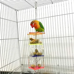 Acrylic bird foraging toy hanging in a cage with colorful plates and clear compartments.