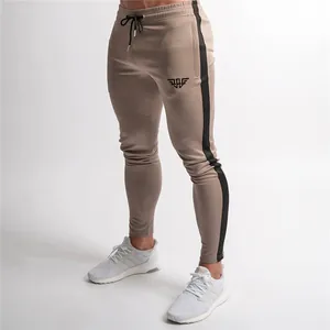 Detailed view of men's slim fit joggers with black side stripes and small logo on thigh.