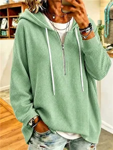 Detail view of sage green women's waffle knit hoodie with white drawstring and zipper