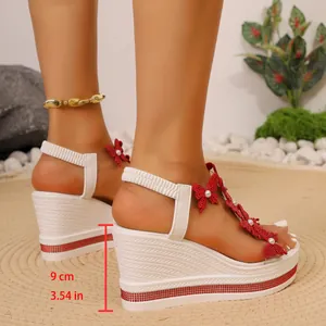 Vue détaillée des sandales compensées blanches avec papillons rouges et talon de 9 cm