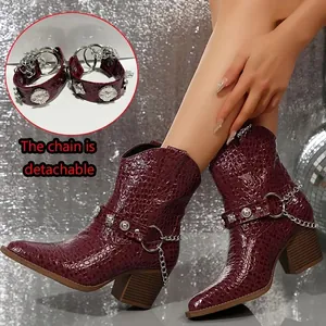 Détail de bottes bordeaux à motif crocodile avec chaînes argentées amovibles