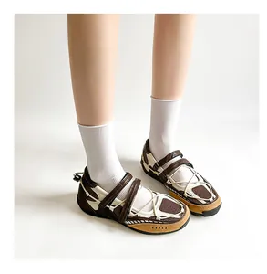 Detailed view of brown sporty Mary Jane ballet flats shown on a model with white socks