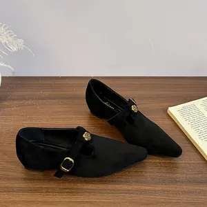 Dettaglio di scarpe Mary Jane in camoscio nero a punta con fibbia a rosa