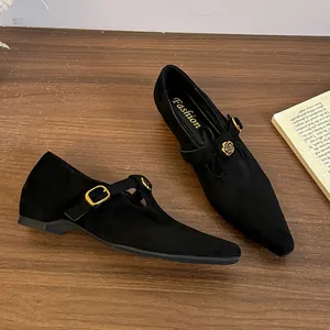 Dettaglio di scarpe Mary Jane in camoscio nero a punta con elegante fibbia a rosa dorata
