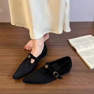 Vista dettagliata delle ballerine Mary Jane in camoscio nero con fibbia a fiore dorato