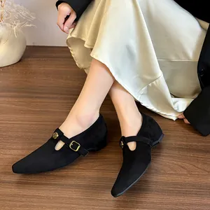 Dettaglio di scarpe Mary Jane nere opache a punta con fibbia floreale dorata vintage