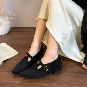 Dettaglio della fibbia a rosa dorata sulle scarpe Mary Jane a punta in camoscio nero.