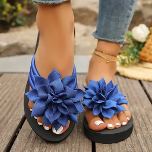 Detalle de chanclas azules para mujer con flores, suelas gruesas y tiras de dedo